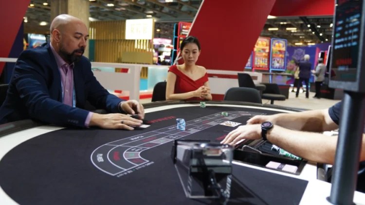 Jugadores en una mesa de casino durante una demostración en feria del sector